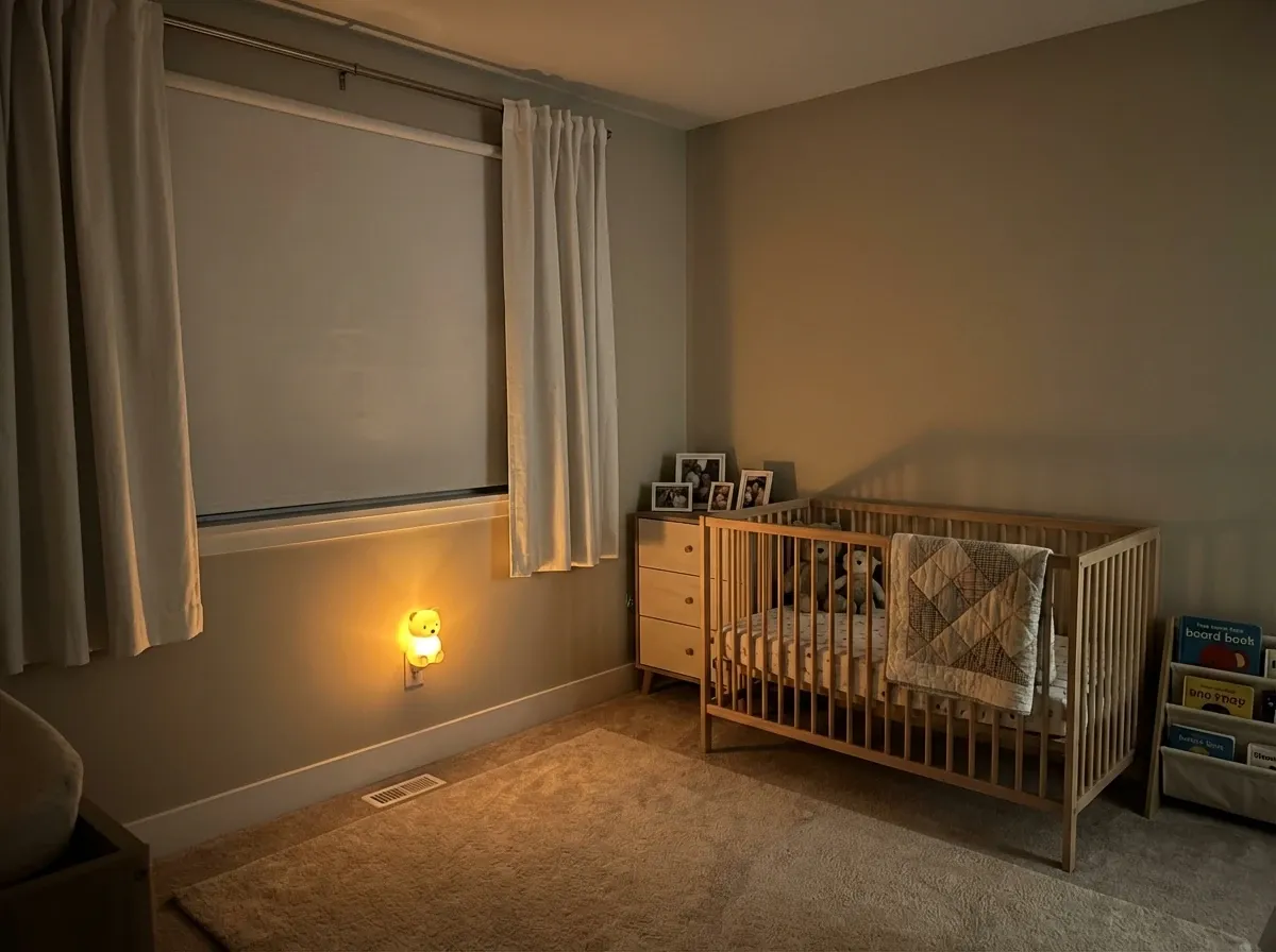 Blackout roller shades fully lowered in a darkened Coquitlam new-build bedroom